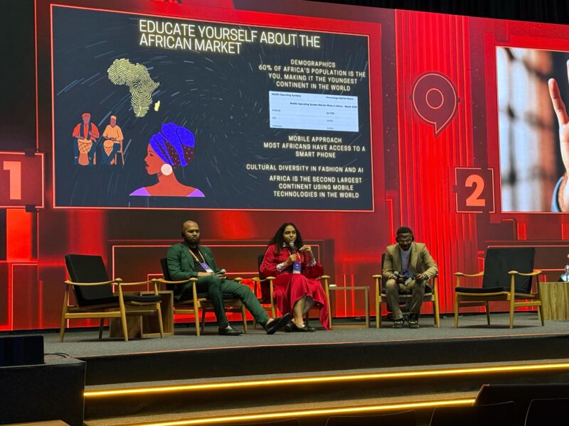 Three people are sitting in chairs on a stage, talking about the African market.