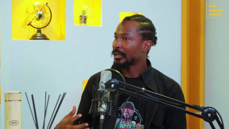 A man wearing a black shirt is talking into a microphone.